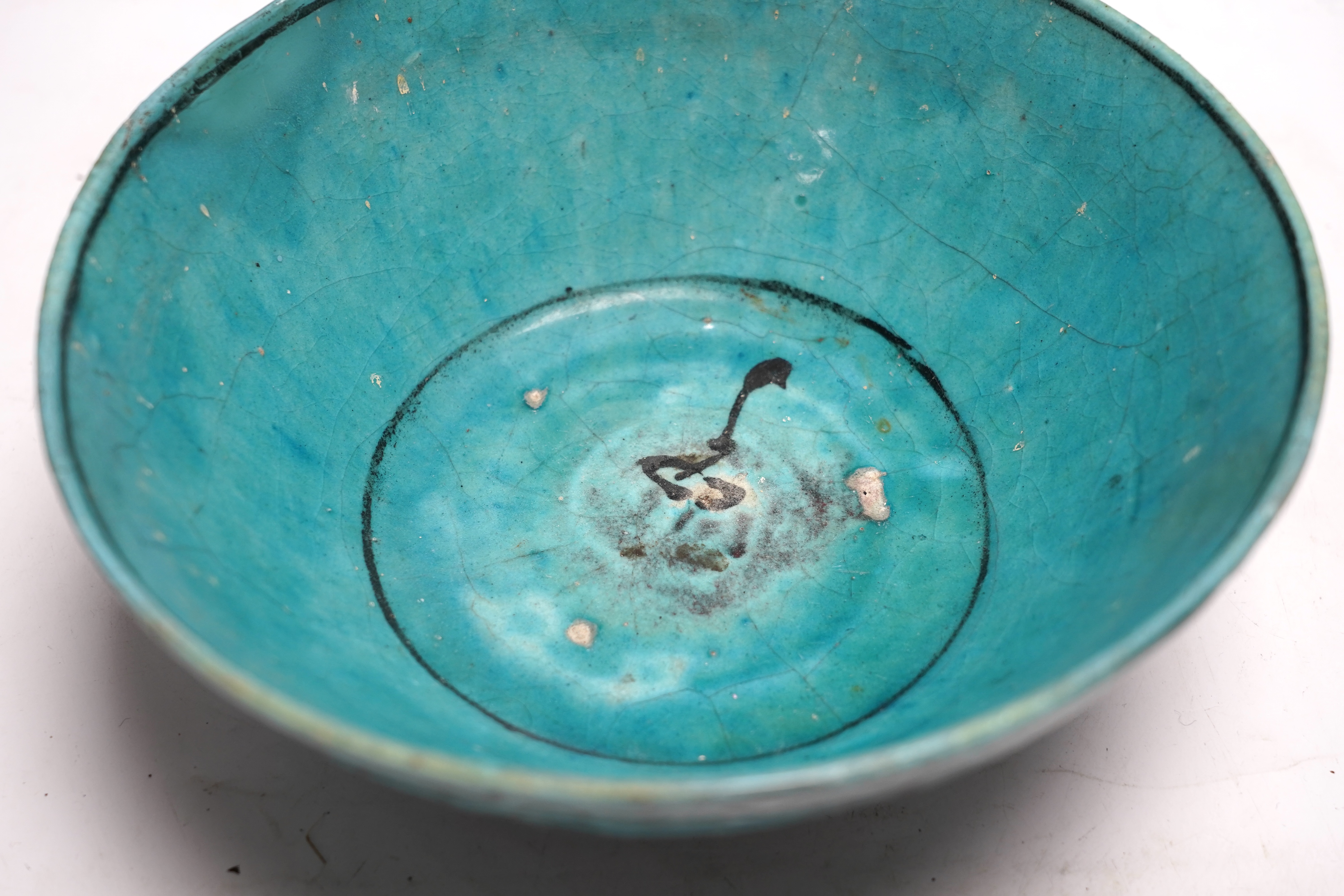 A Kashan turquoise glazed fritware bowl, Persia, 13th/14th century, 25cm diameter